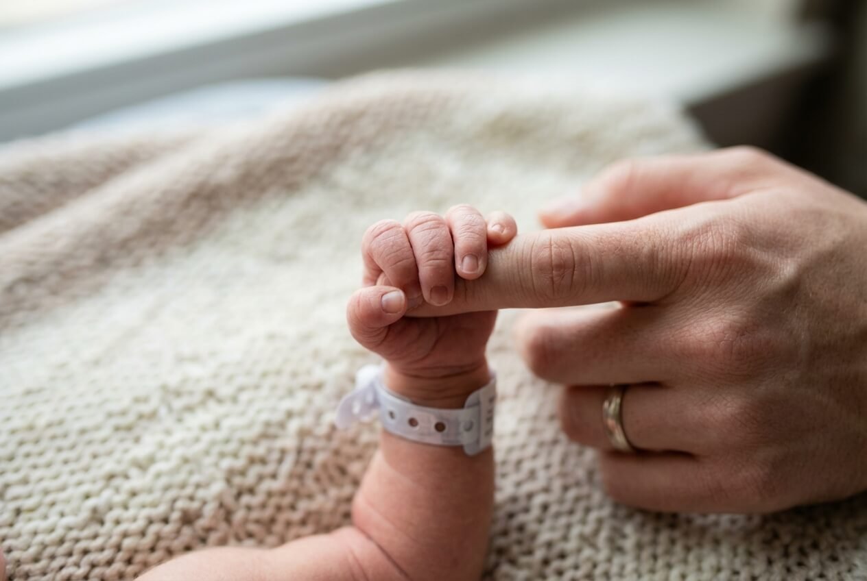 A parent holding a newborn at home